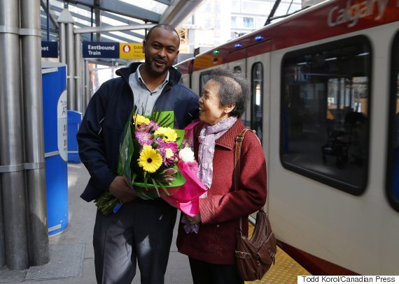   Li Feng Yang delivers flowers for CTrain operator Mesfin Tadese in Calgary on Tuesday. (Photo: Todd Korol/Canadian Press)  